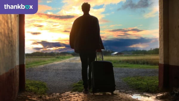 Silhouetted person with suitcase