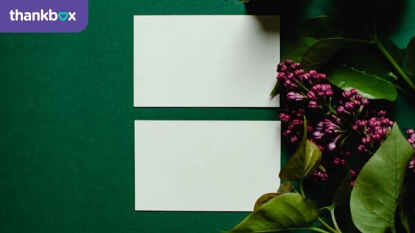 Lilac Flowers Beside White Blank Papers on Green Background