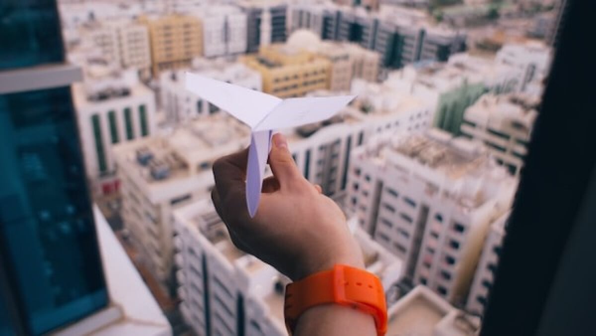 shallow focus photography of person holding paper plane