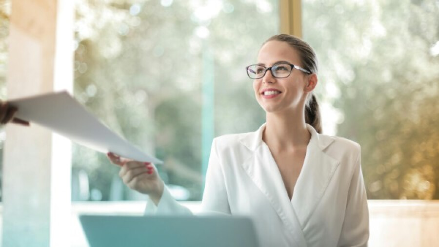 Positive businesswoman doing paperwork in office