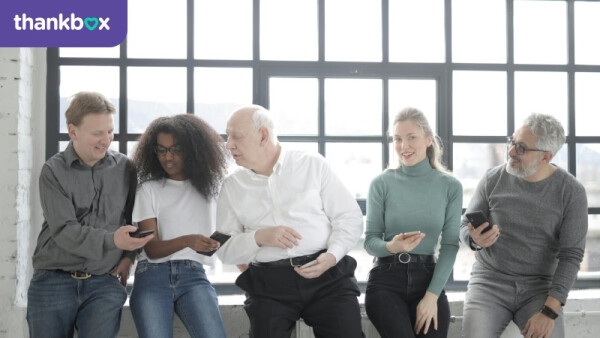 Group of people on their phones while seated by a window
