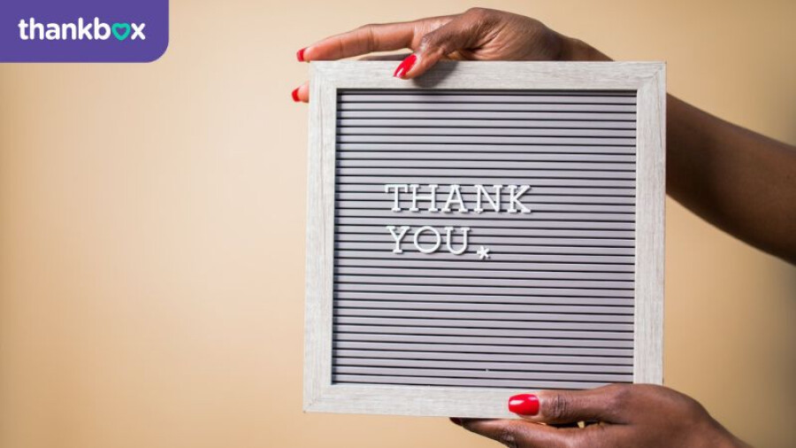 A Person Holding a Gray Thank You Signage